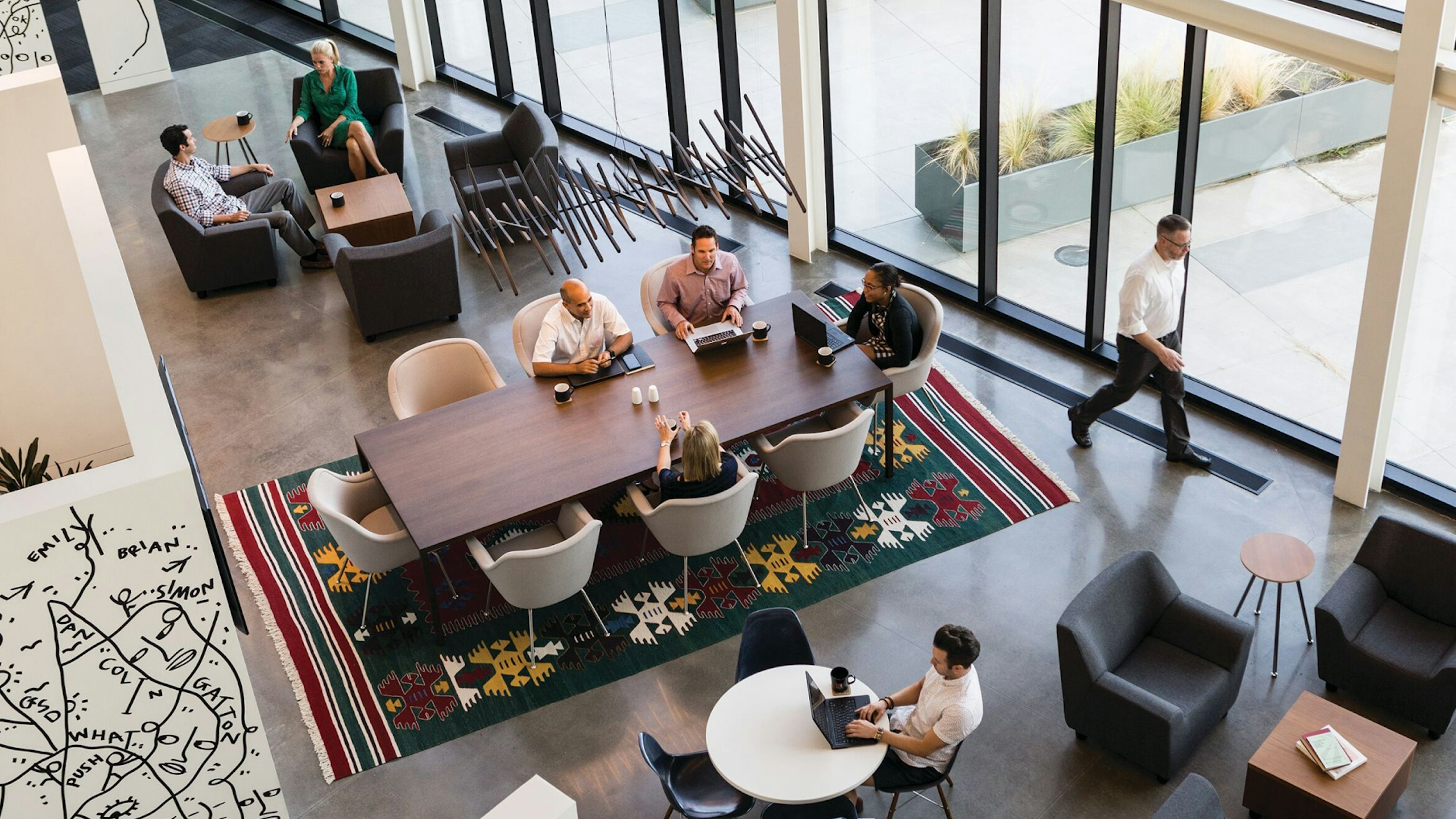 An overhead view of an office lounge area situated near windows.